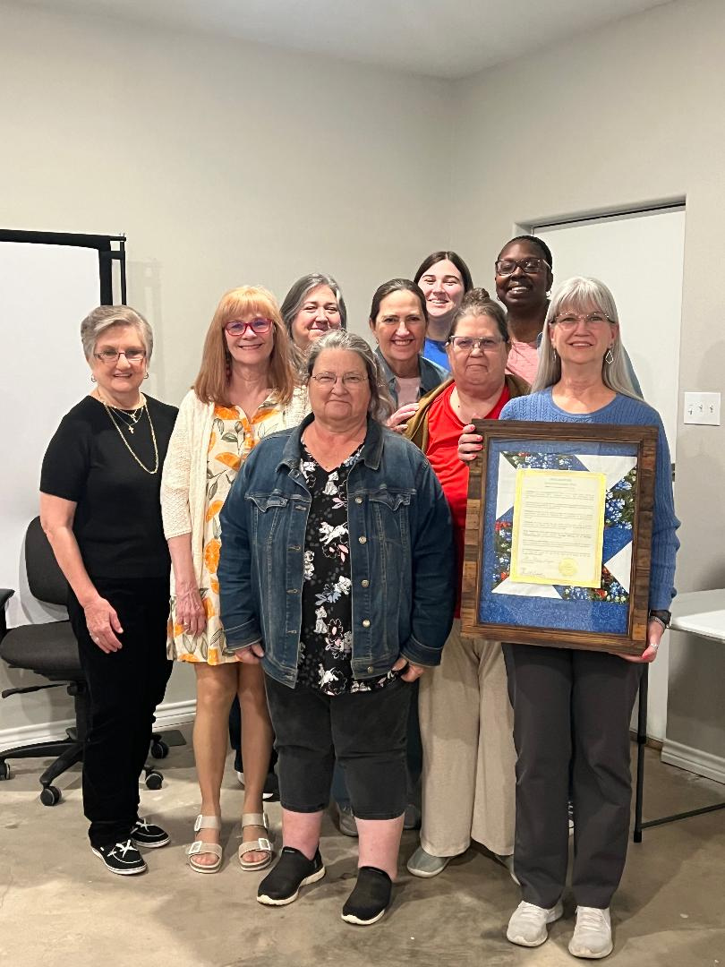 group of ladies accepting the proclamation and quilt shadow box for Bonnie Levandowski